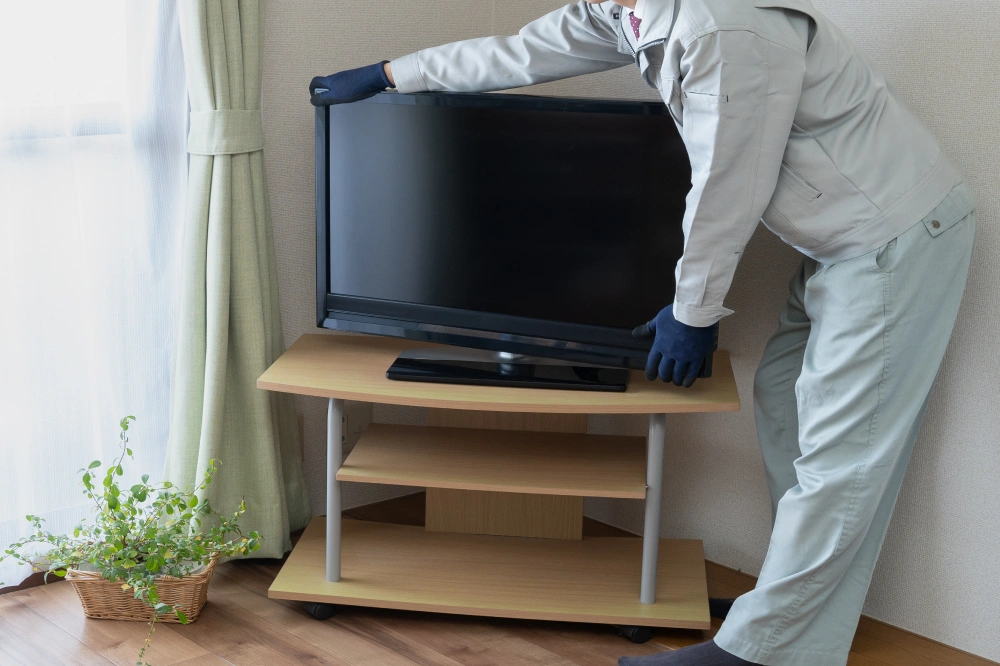 テレビを運ぶ作業員